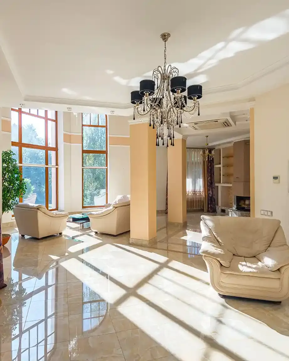 Sunlit living room with 3M sun-control window film on the floor-to-ceiling windows, cutting glare and heat on the marble floor.