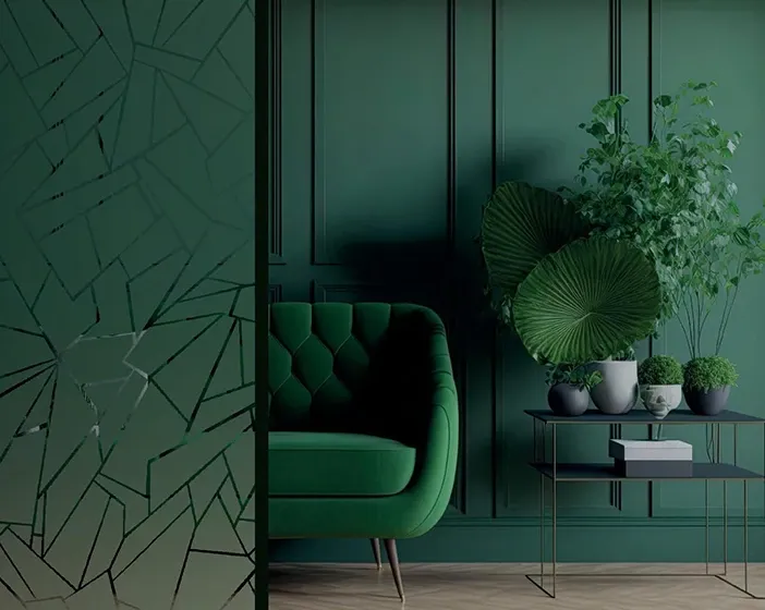 Geometric patterned decorative film on a glass panel beside a green velvet armchair