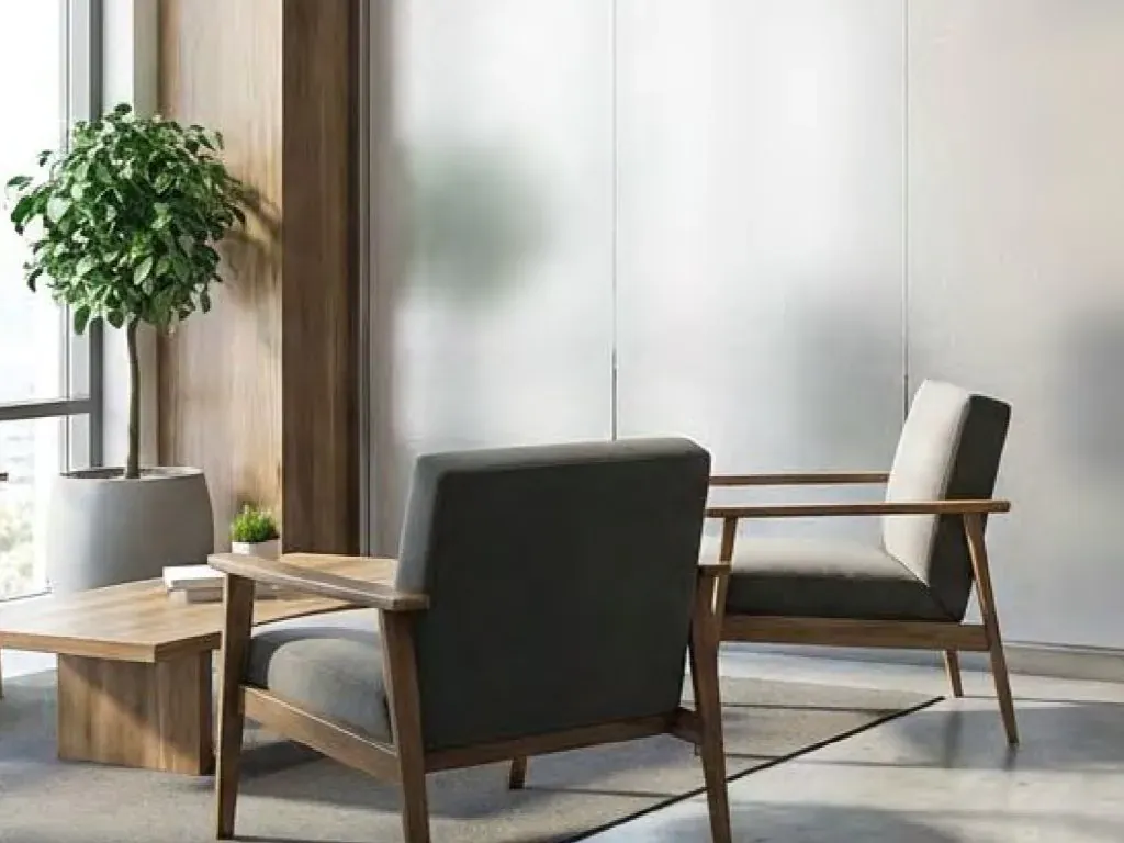 Frosted film on a full height glass partition beside a seating area, daylight passing through while the space behind stays hidden