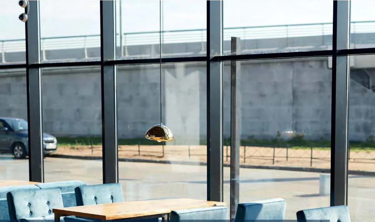 A glazed breakout space with full height windows, sun on the floor and the view kept