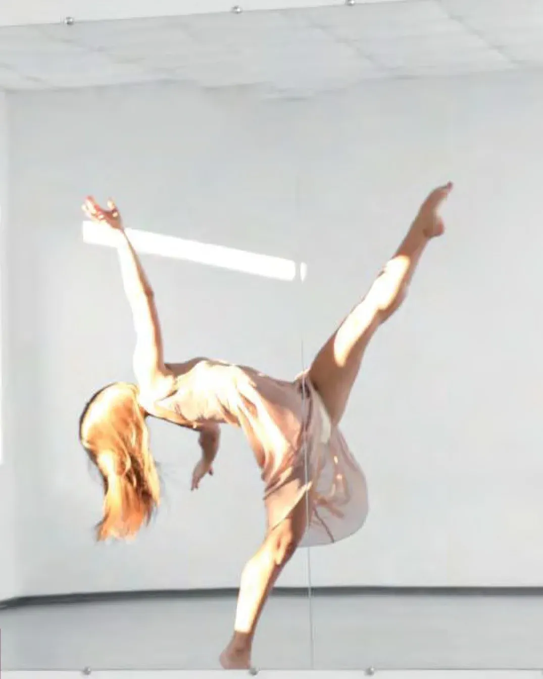 Dancer reflected in a studio wall glazed with one-way mirror film