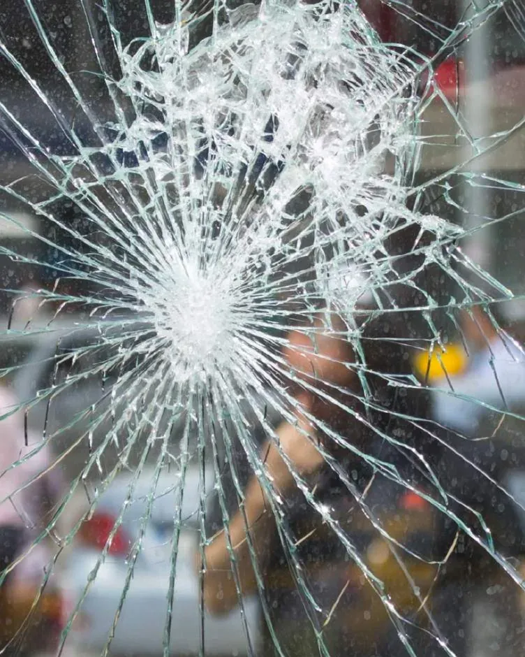 Impact-shattered shopfront pane held together in one sheet by SEC 054X security film